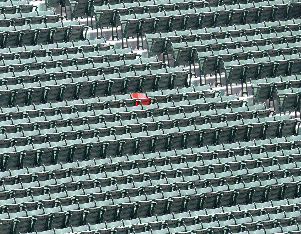 The single red seat among green bleachers at Fenway Park