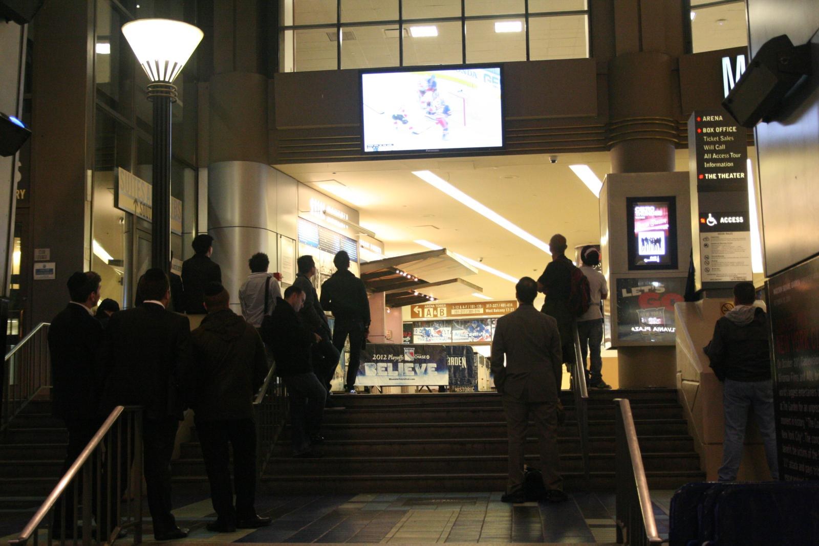 Fans standing outside the Madison Square Garden box office at night, with the Box Office and Will Call sign lit on the right
