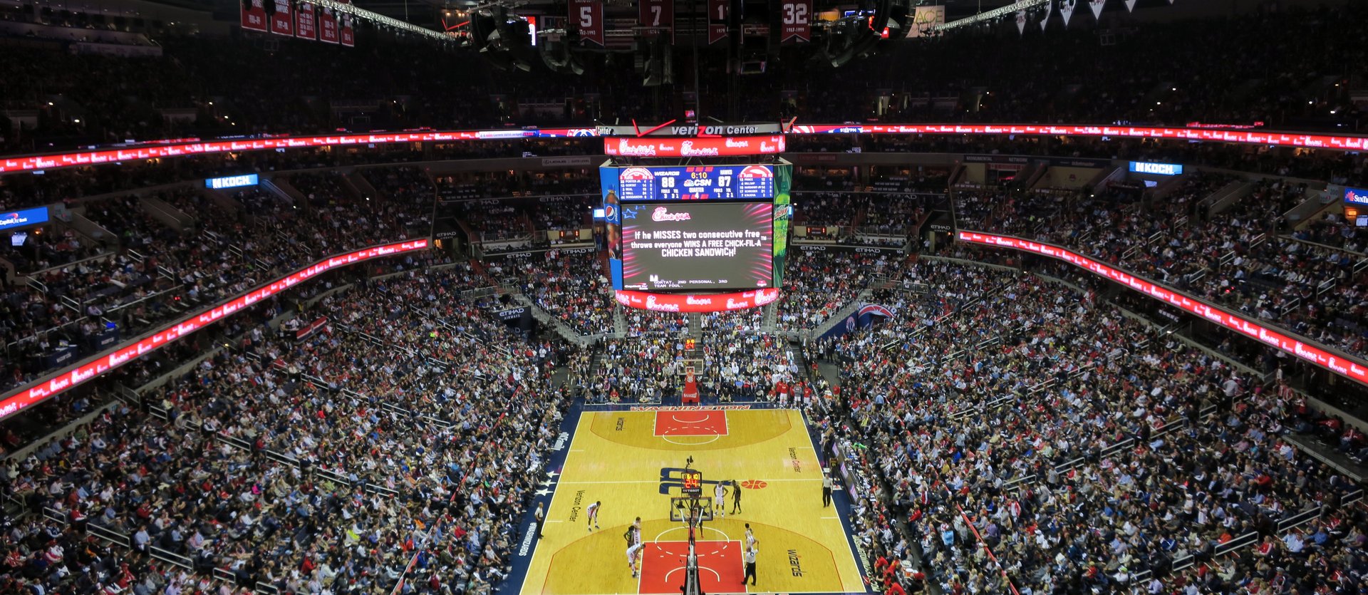 A packed NBA arena seen from the upper level during a game